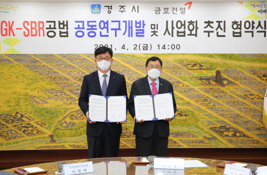 이명재(왼쪽) 금호건설 토목플랜트본부장과 주낙영 경주시장이 지난 2일 고도하수처리기술 개발 및 사업화 추진 공동연구협약 체결 후 기념 사진을 찍고 있다. <금호건설 제공>